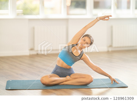 Young woman practicing vinyasa yoga in studio Young woman practicing vinyasa yoga in studio 128961309