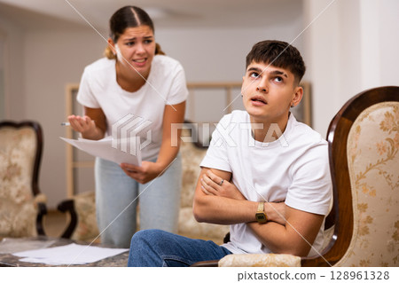 Upset young wife with documents swears at her husband Upset young wife with documents swears at her husband 128961328