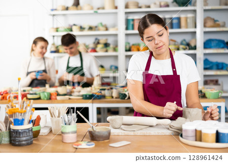 Young woman cutting row clay cup 128961424