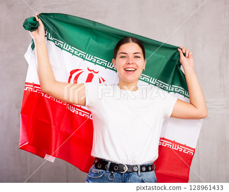 Smiling young woman holding Iran flag 128961433