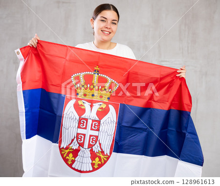 Portrait of positive young woman with flag of Serbia 128961613