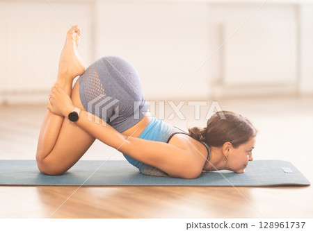 Young woman practicing vinyasa yoga in studio Young woman practicing vinyasa yoga in studio 128961737