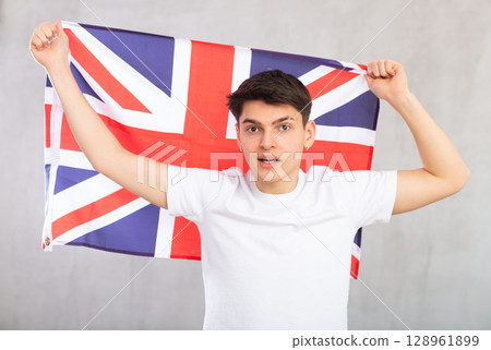 Male football fan holding Great Britain flag 128961899