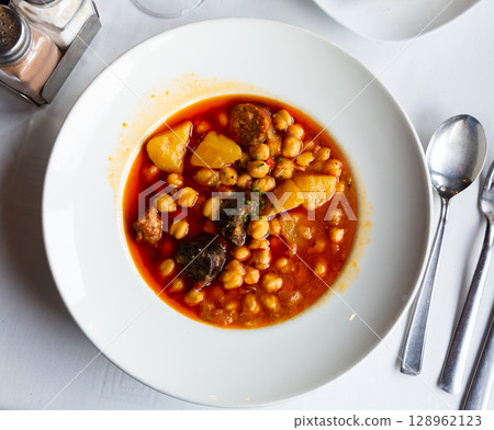 Chickpea soup with chorizo served on table Chickpea soup with chorizo served on table 128962123