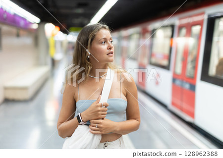 Young girl standing in platform with wireless headphones on airs Young girl standing in platform with wireless headphones on airs 128962388