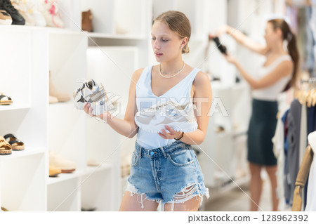 Young woman choosing sneakers in the store 128962392
