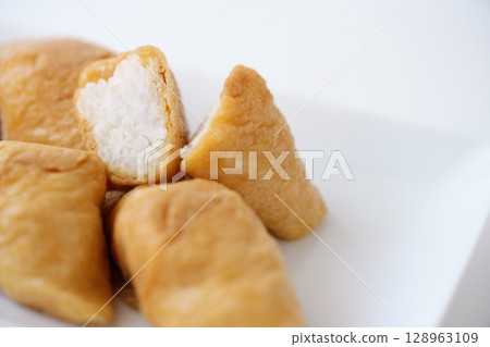 The contrast between the soft brown of the plump fried tofu and the glossy white of the vinegared rice (before thawing) 128963109