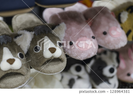 Fluffy slippers with animal designs on display and for sale Fluffy slippers with animal designs on display and for sale 128964381