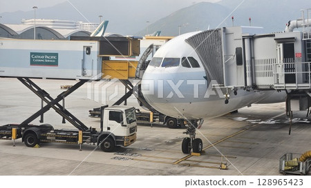 Hong Kong, China - 12th July 2025 - This is Hong Kong airport with ATC tower and a Cathay Pacific aeroplane. 128965423