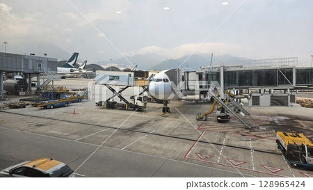Hong Kong, China - 12th July 2025 - This is Hong Kong airport with ATC tower and a Cathay Pacific aeroplane. 128965424