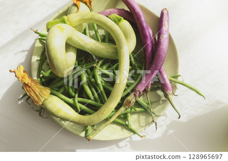 Unusually shaped vegetables on plate. Zucchini and eggplant, asparagus beans. Seasonal food and farm organic produce. Unusually shaped vegetables on plate. Zucchini and eggplant, asparagus beans. Seasonal food and farm organic produce. 128965697