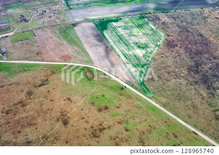 Aerial view of winding rural road among autumn fields, patchwork landscape Aerial view of winding rural road among autumn fields, patchwork landscape 128965740