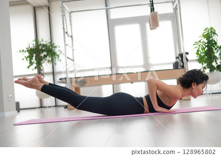 Asian woman doing yoga in studio. Asian woman doing yoga in studio. 128965802