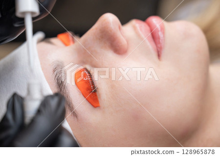 Caucasian woman undergoing eyelash lamination procedure. Caucasian woman undergoing eyelash lamination procedure. 128965878