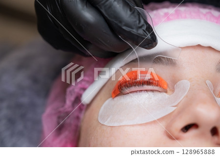 Caucasian woman undergoing eyelash lamination procedure.  128965888