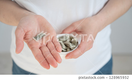 A woman holds a jar of chewing tobacco.  A woman holds a jar of chewing tobacco.  128965932