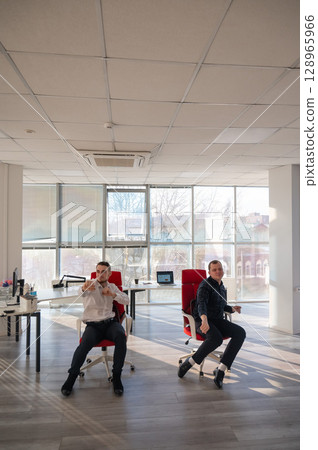 Two Caucasian men having fun at work. Two Caucasian men having fun at work. 128965966