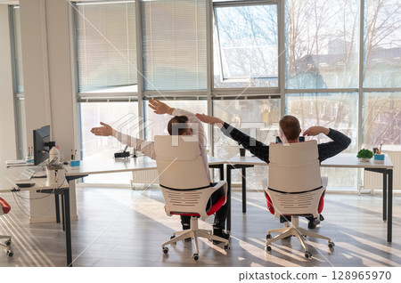 Two Caucasian men having fun at work. Two Caucasian men having fun at work. 128965970