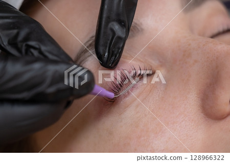 The process of professional eyelash lamination in a salon. The process of professional eyelash lamination in a salon. 128966322