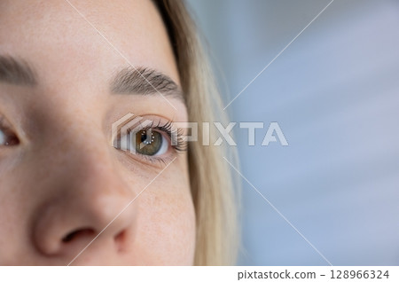 Close-up of a woman's eye after eyelash lamination procedure.  128966324