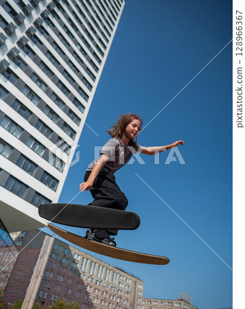 Girl practices skiing tricks on a trampoline.  128966367