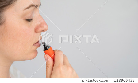 Caucasian woman smoking disposable vape. Caucasian woman smoking disposable vape. 128966435
