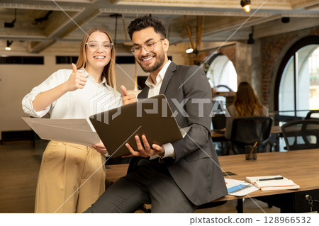 Colleagues discussing something and looking joyful and excited Colleagues discussing something and looking joyful and excited 128966532
