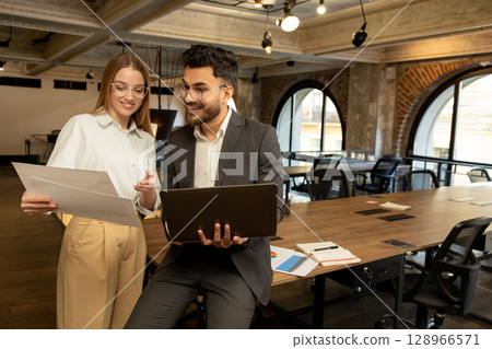 Colleagues in the office discussing project details and looking involved Colleagues in the office discussing project details and looking involved 128966571