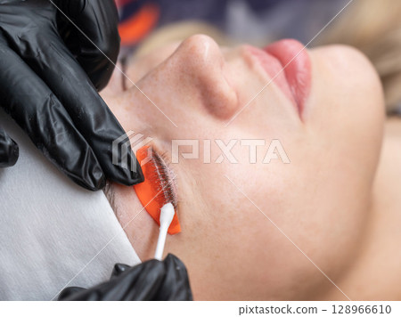 Caucasian woman undergoing eyelash lamination procedure. Caucasian woman undergoing eyelash lamination procedure. 128966610