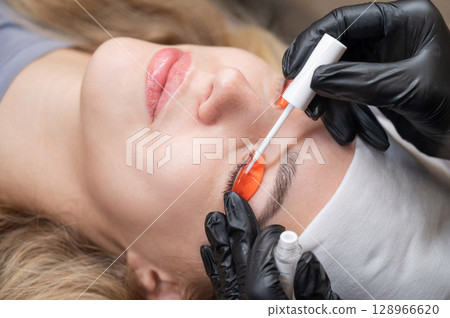 Caucasian woman undergoing eyelash lamination procedure.  128966620