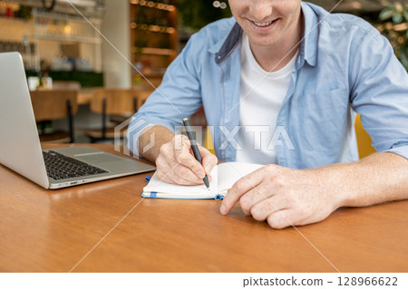 Ginger young man sitting at the table in the cafe 128966622