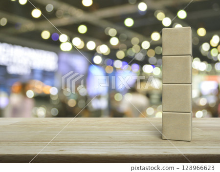 Four wood block cubes on wooden table 128966623
