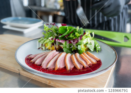 The chef serves roast duck.  128966791