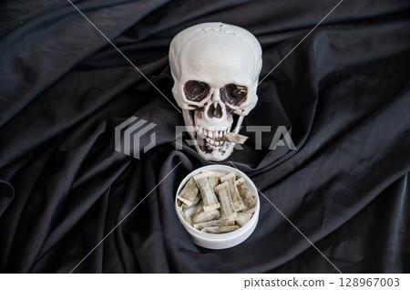 Skull Chewing Tobacco on Black Cloth. Skull Chewing Tobacco on Black Cloth. 128967003