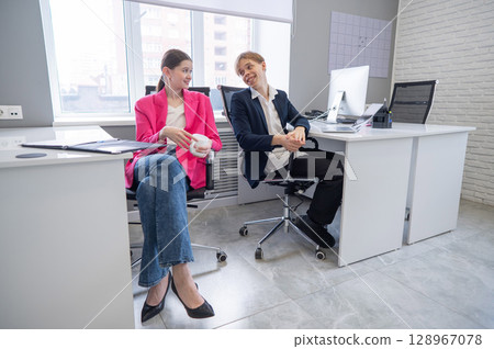 Colleagues communicate while at work in the office.  128967078