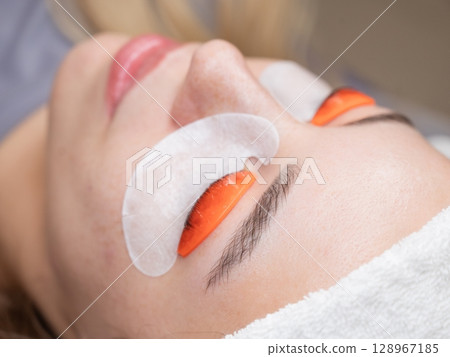Caucasian woman undergoing eyelash lamination procedure.  128967185