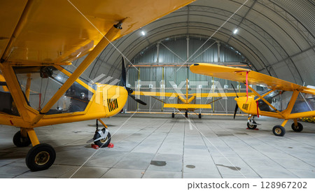 Yellow airplane glider in the hangar.  128967202