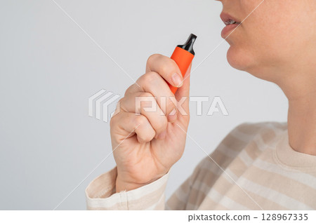 Caucasian woman smoking disposable vape. Caucasian woman smoking disposable vape. 128967335
