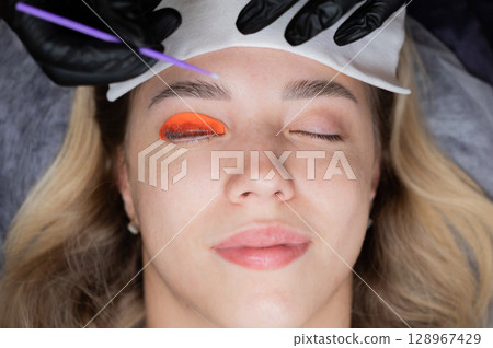 Caucasian woman undergoing eyelash lamination procedure. Caucasian woman undergoing eyelash lamination procedure. 128967429