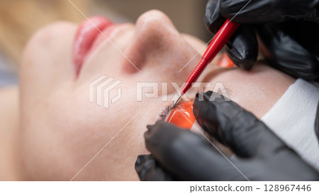Caucasian woman undergoing eyelash lamination procedure. Caucasian woman undergoing eyelash lamination procedure. 128967446