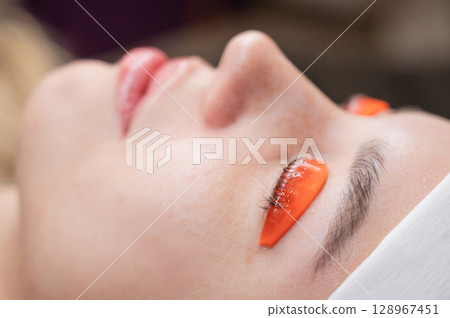 Caucasian woman undergoing eyelash lamination procedure.  128967451