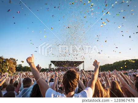 People gathering and enjoying an outdoor festival under a blue sky Confetti 128967476
