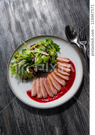 Roasted duck cut into pieces on a plate.  128967571