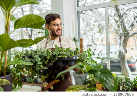 Young man working in the flower shop and feeling contented 128967699