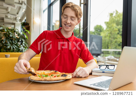 Young man in pizzeria looking positive and preparing to eat pizza 128967721