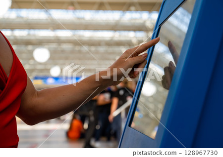 Interacting with a touchscreen kiosk at an airport.  128967730