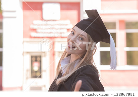 Portrait of a young Caucasian woman in a graduation gown.  128967991