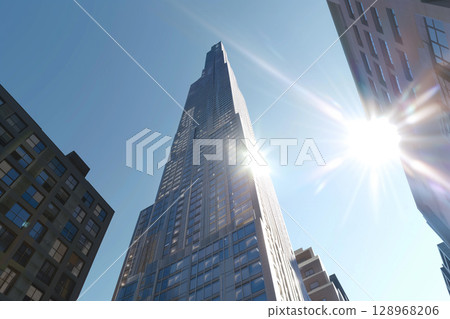 Stunning low-angle shot of a skyscraper under bright blue sky 128968206
