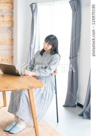 A pregnant woman working from home in the living room 128970190