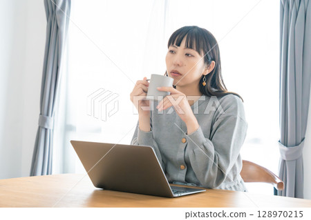A pregnant woman working from home in the living room 128970215